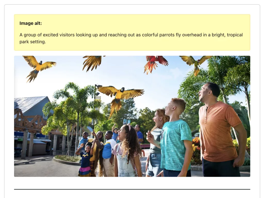 An example image of "a group of excited visitors looking up and reaching out as colorful parrots fly overhead" with AI-generated alt text